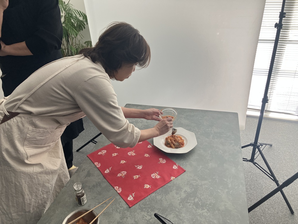 「さばのコクうまケチャップ炒め」を盛り付け中の沼津先生